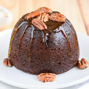 Christmas Pudding with Butterscotch Sauce On A White Plate