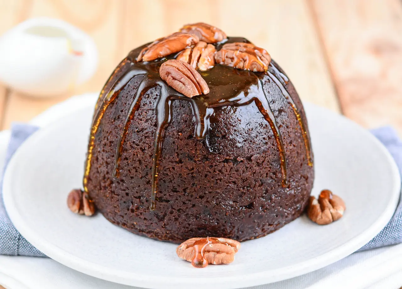 Christmas Pudding with Butterscotch Sauce On A White Plate