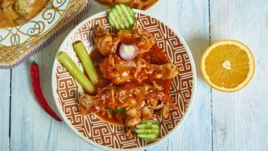 Kashmiri Chicken on a White Table Next to Orange