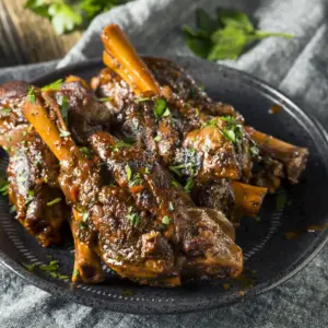 Lamb Shanks in Red Wine on a Black Plate