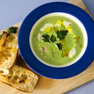 Pea and Ham Soup with Cream & Baguette on Rustic Board