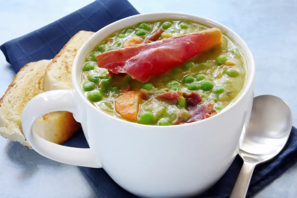 Pea and Ham Soup on a White Glass 