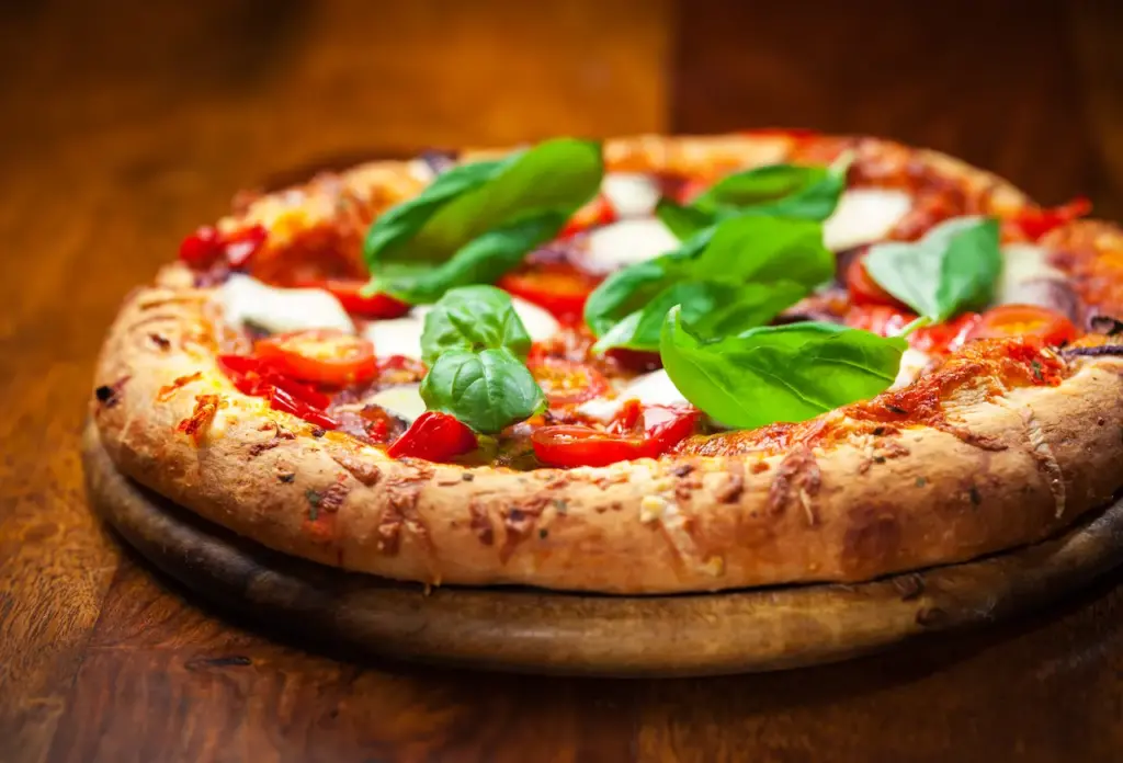 Pizza With Tomato and Green Leaves on Top