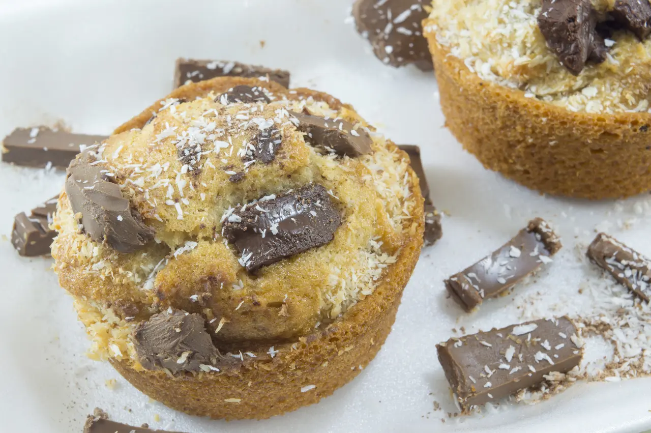 White Chocolate & Coconut Muffins On A White Plate