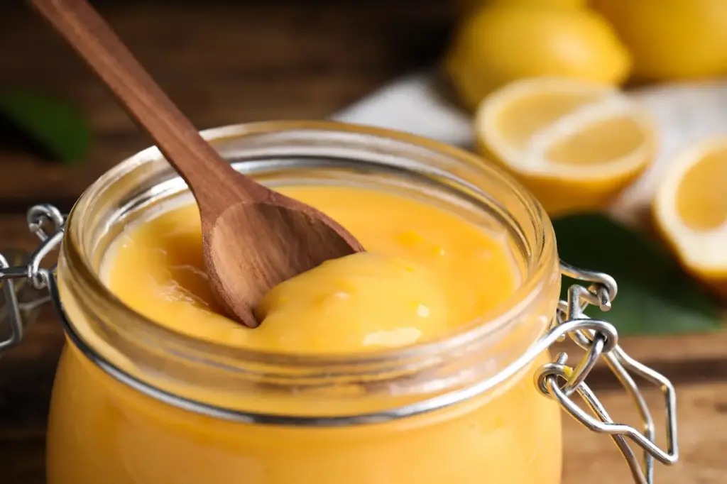 Lemon Curd in Jar with Wooden Spoon 