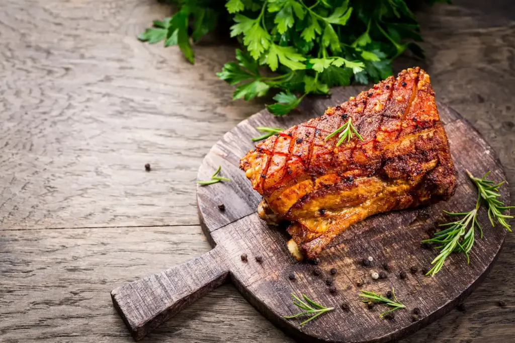 Roast Pork Belly With Crust And Herbs On Cutting Board