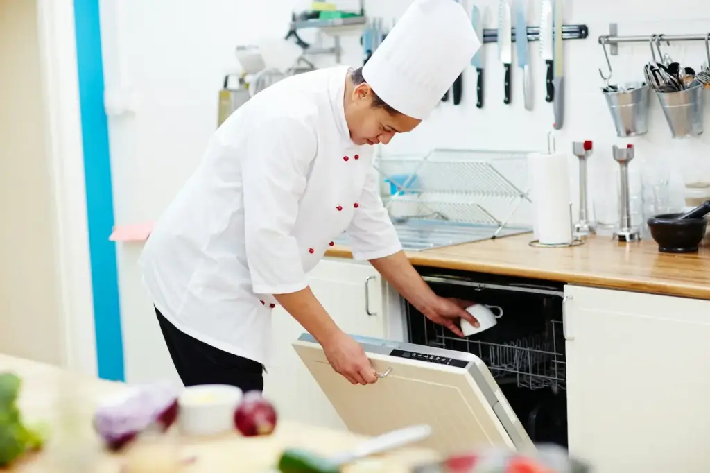 Chef Using A Residential Dishwasher In A Kitchen